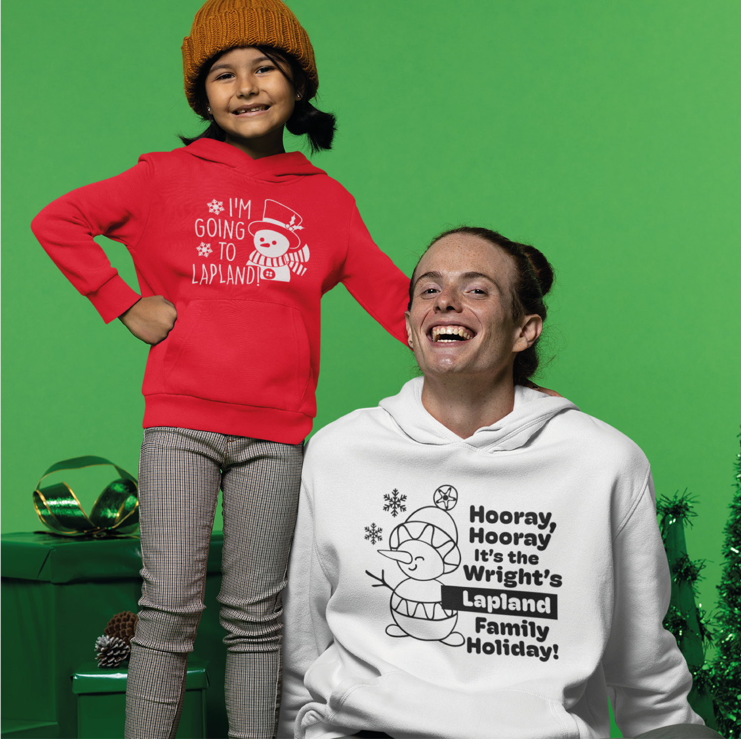 Image of a girl and a woman. Girl is wearing a red hoodie that says 'i'm going to Lapland' the Woman is wearing a white hoodie that says 'hooray hooray it's the wright's lapland family holiday!"