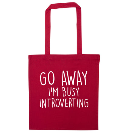 Go away I'm busy introverting red tote bag