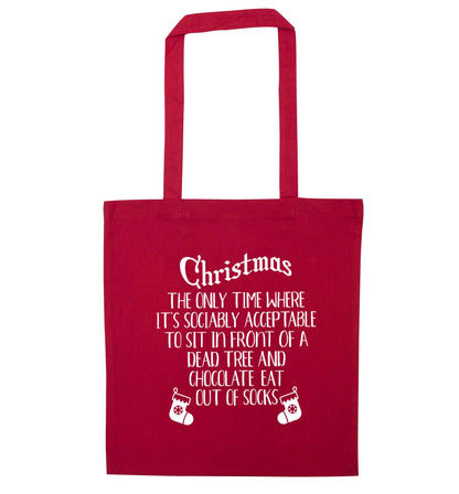 Christmas sit in front of a dead tree and eat chocolate out of socks red tote bag
