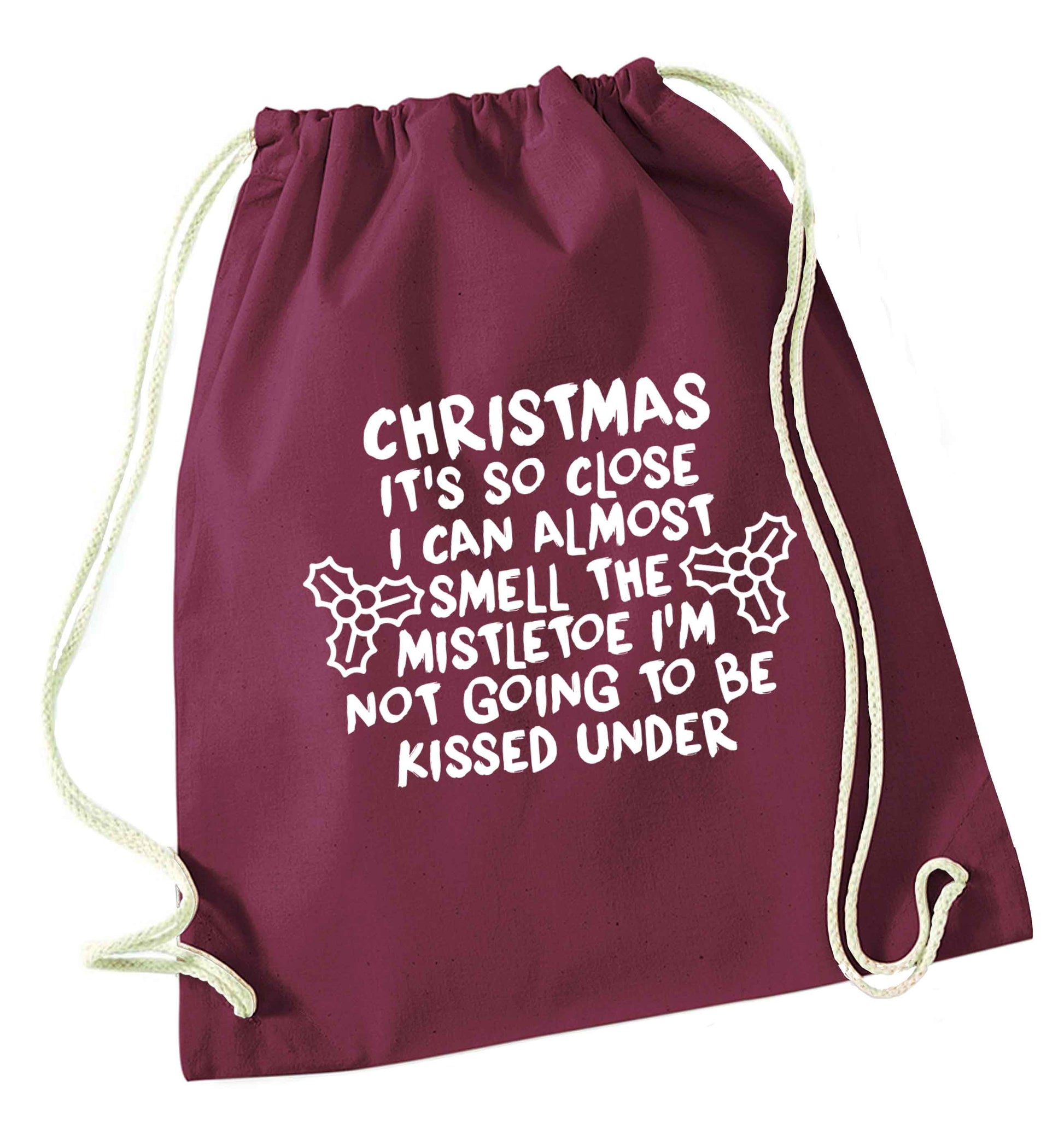 Christmas it's so close I can almost smell the misteltoe I'm not going to be kissed under maroon drawstring bag