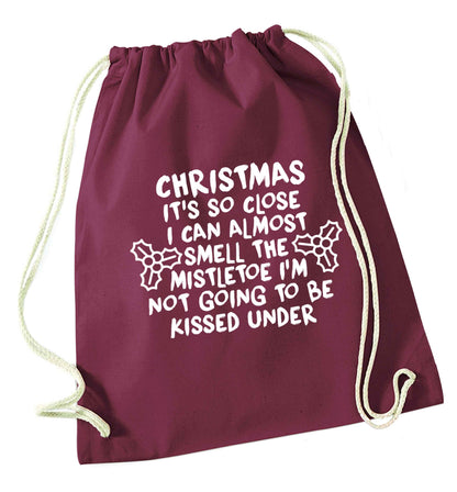 Christmas it's so close I can almost smell the misteltoe I'm not going to be kissed under maroon drawstring bag